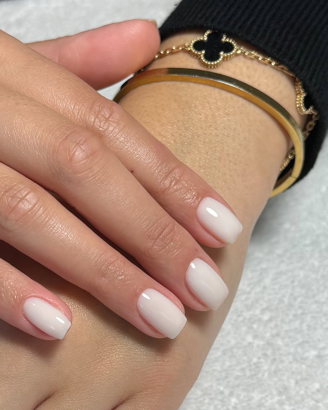 Glossy white nails with elegant gold accents