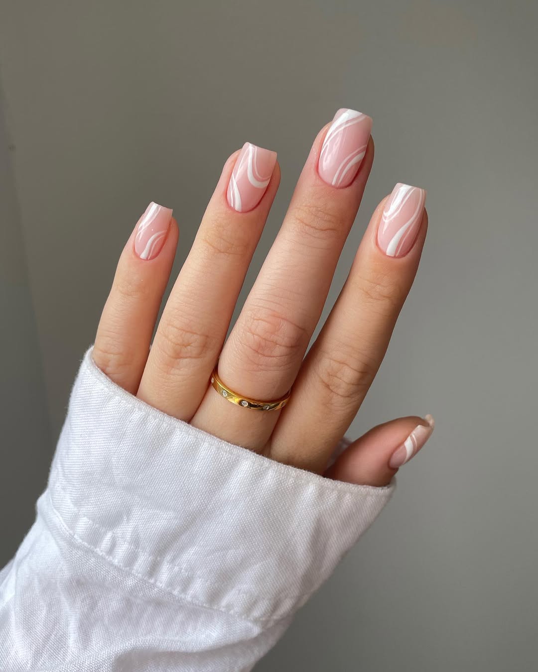 Trendy pink marble nail design with white accents