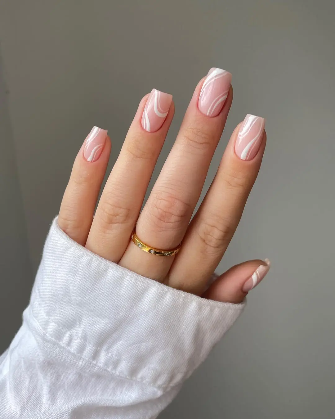 Trendy pink marble nail design with white accents