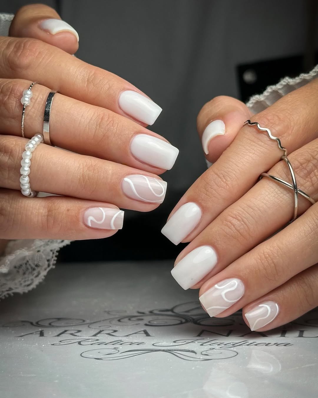 Sleek white nails with elegant swirl designs