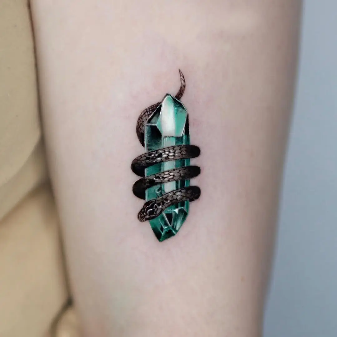 Intricate snake entwined around mystic crystal tattoo