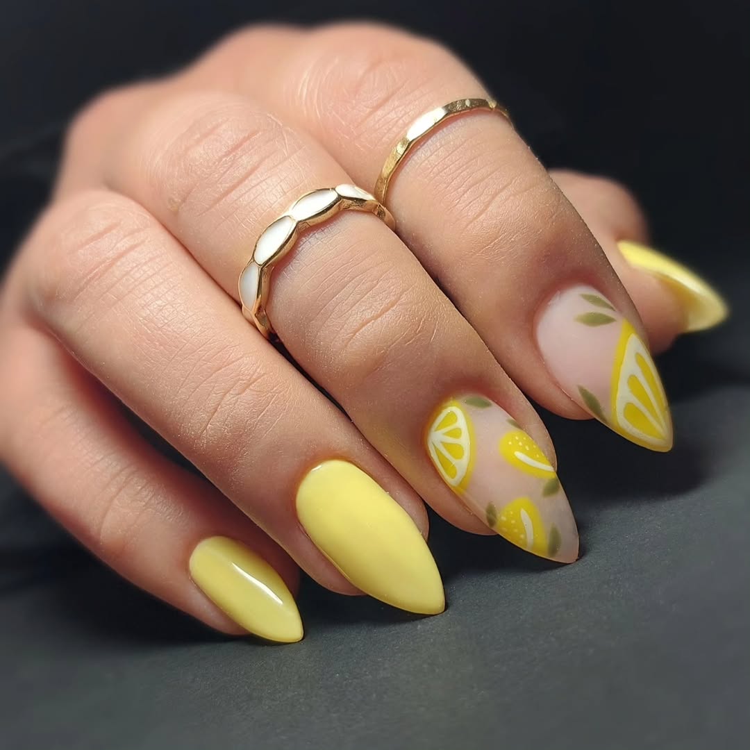 Bright yellow nails with playful lemon designs