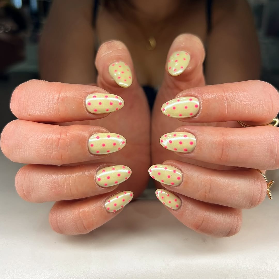 Playful yellow nails adorned with pink dots