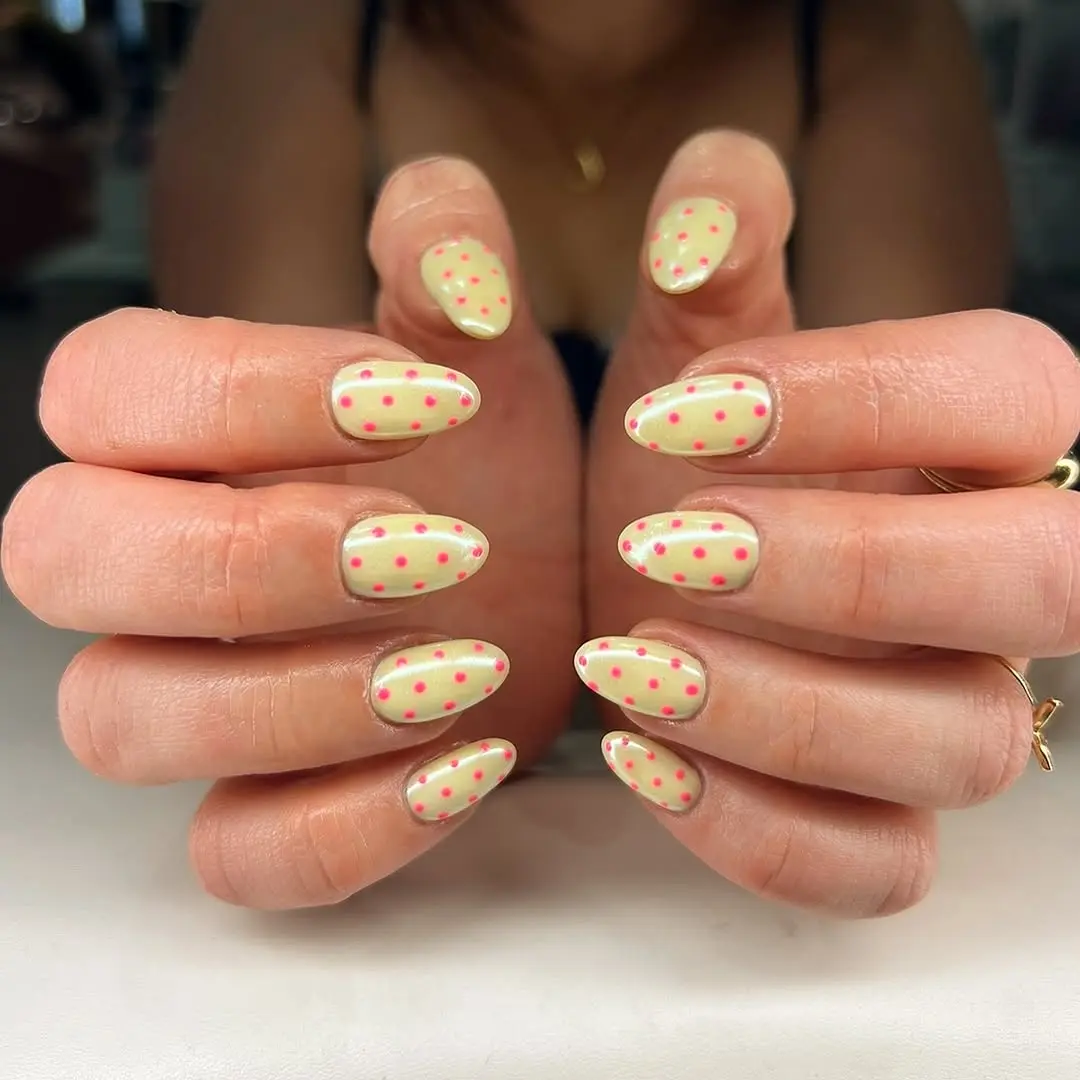 Playful yellow nails adorned with pink dots