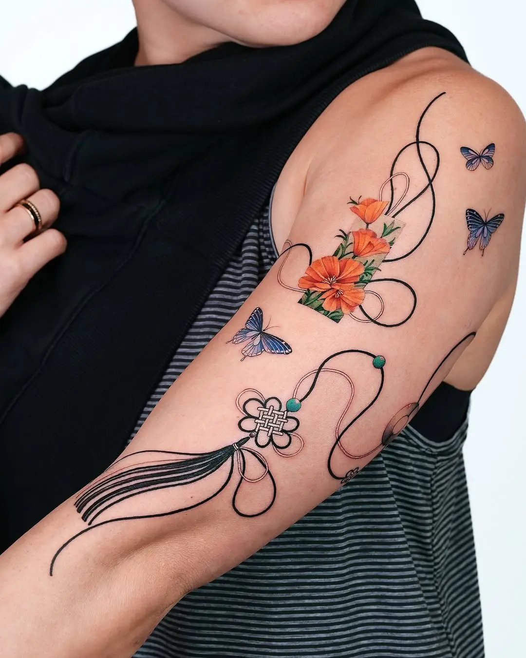 Vibrant floral and butterfly arm tattoo design