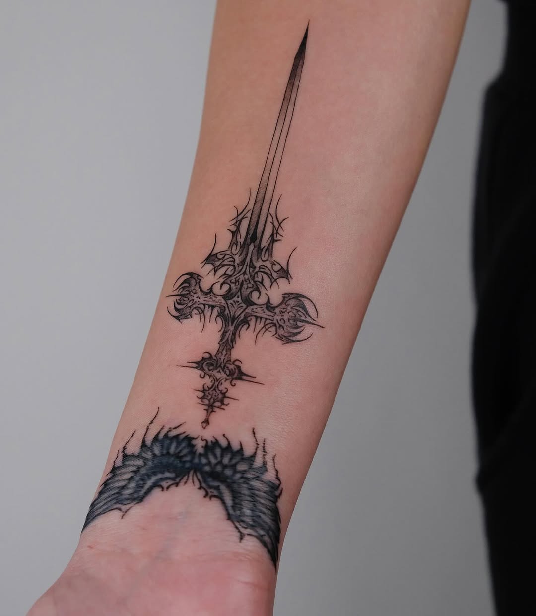 Elegant sword tattoo with intricate details.