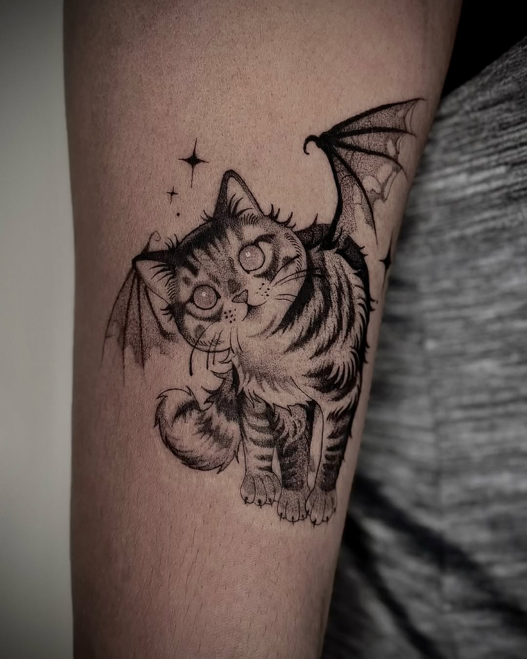 Whimsical bat-winged cat tattoo design