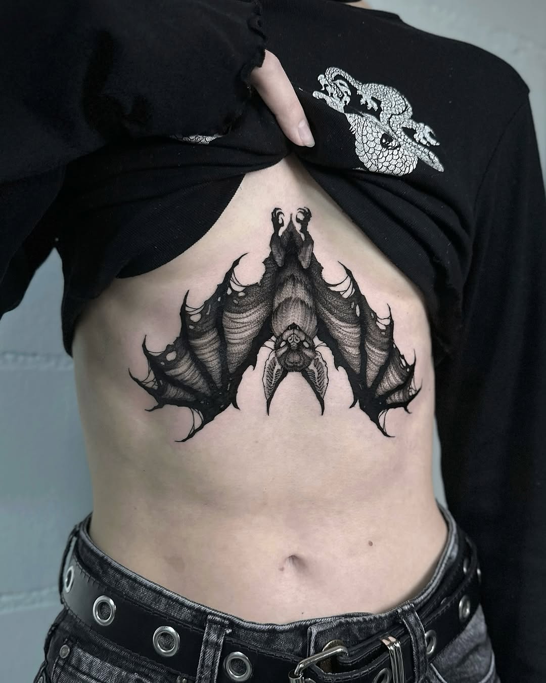 Intricate bat tattoo enhances personal expression.