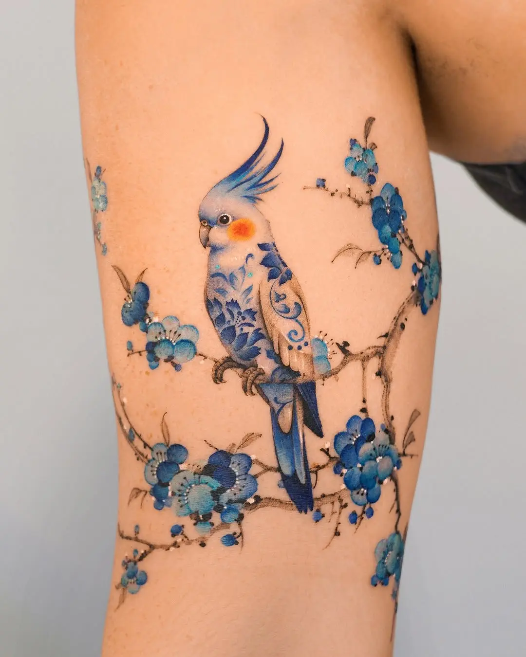 Vibrant Bird Tattoo with Floral Elements