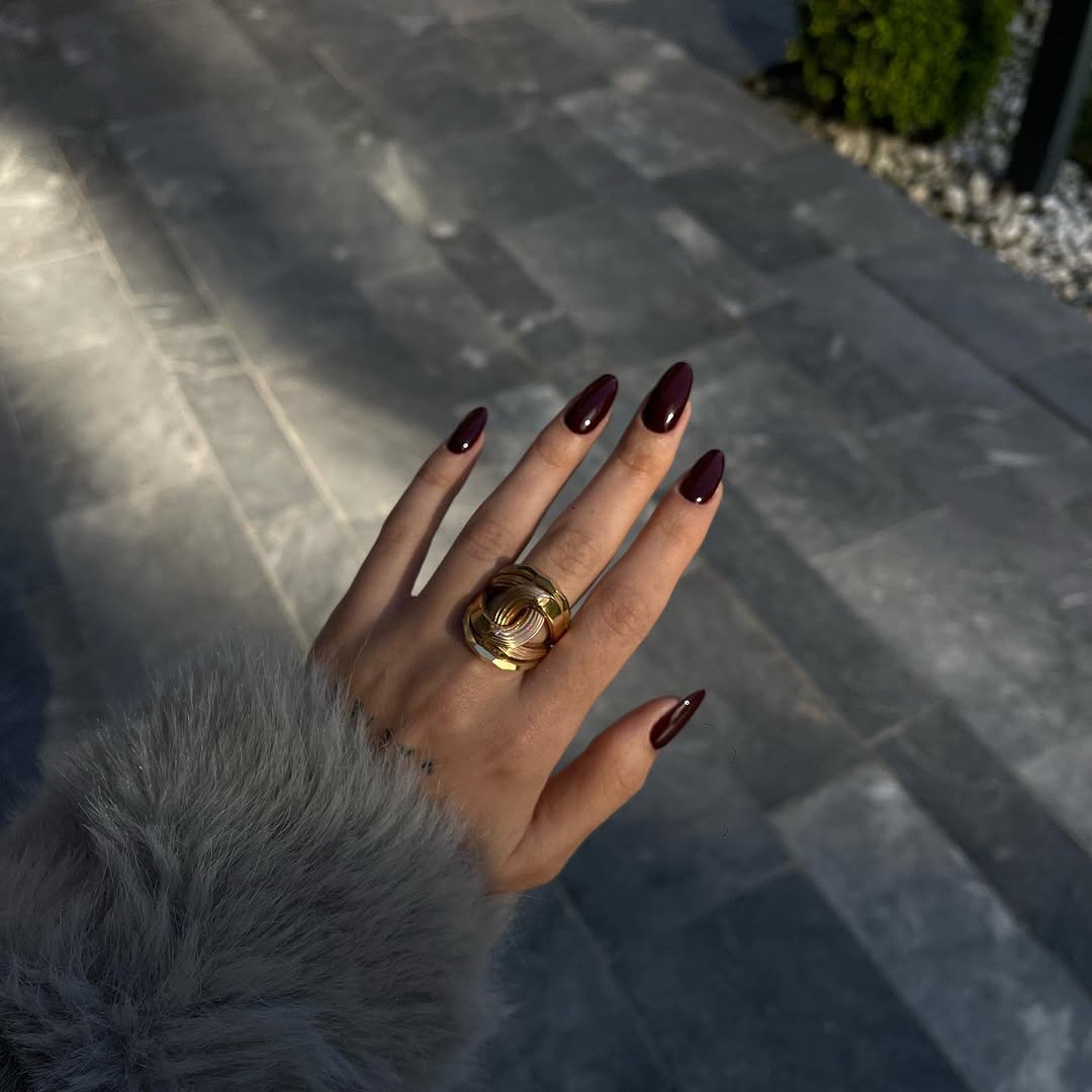 Elegant burgundy nails with a bold ring