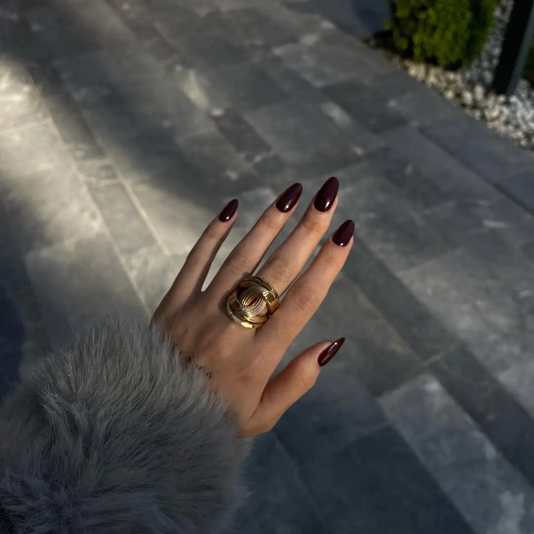 Elegant burgundy nails with a bold ring