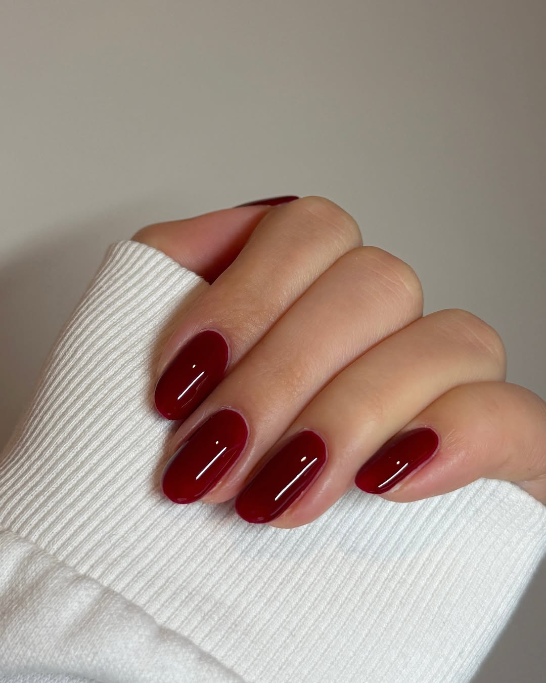 Glossy burgundy nails with a cozy touch