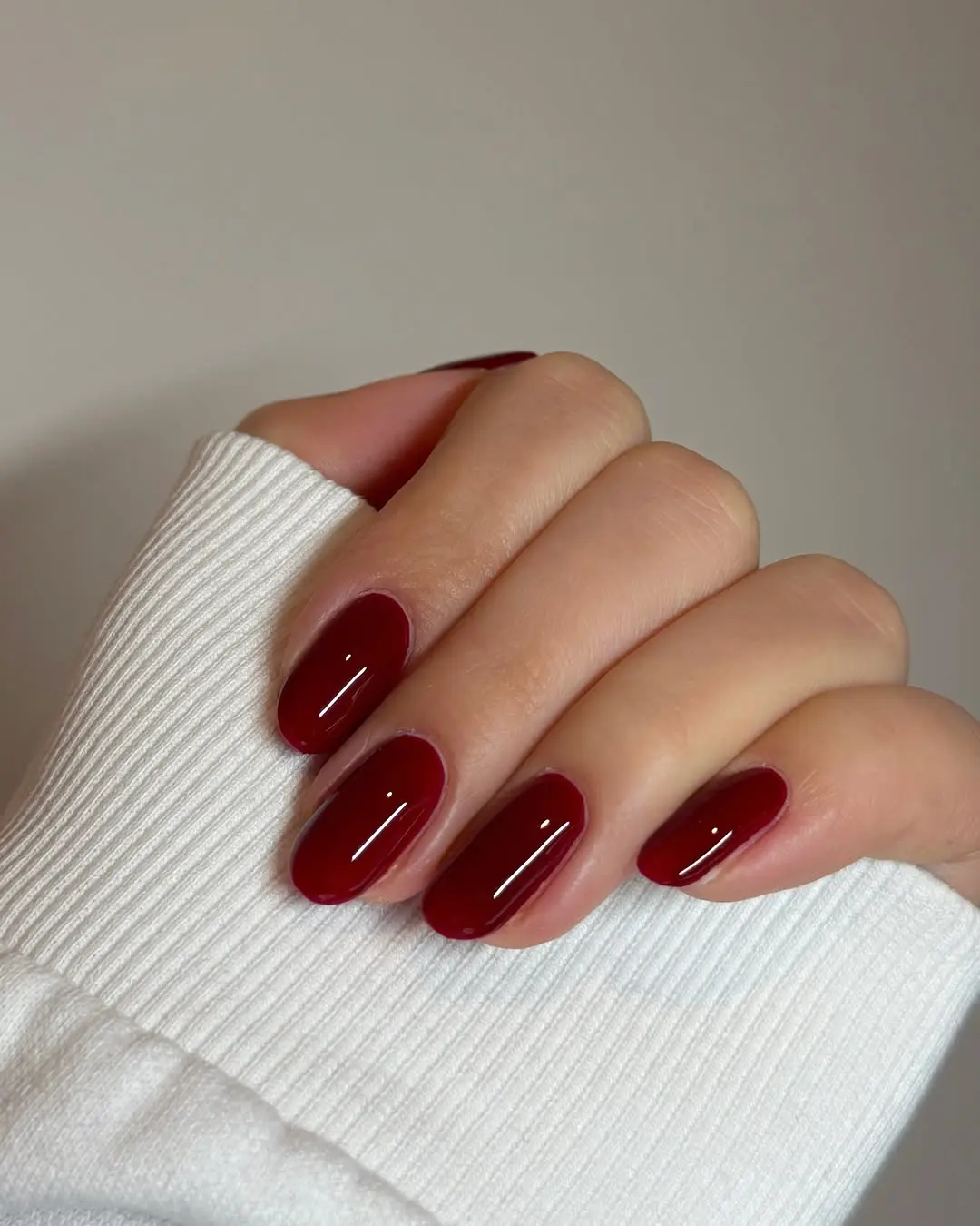 Glossy burgundy nails with a cozy touch