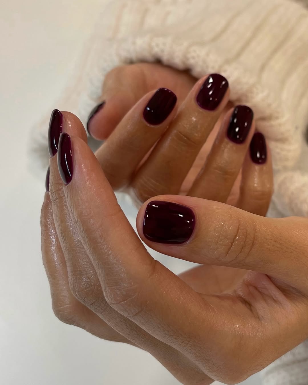 Elegant burgundy nails enhance graceful hand gesture