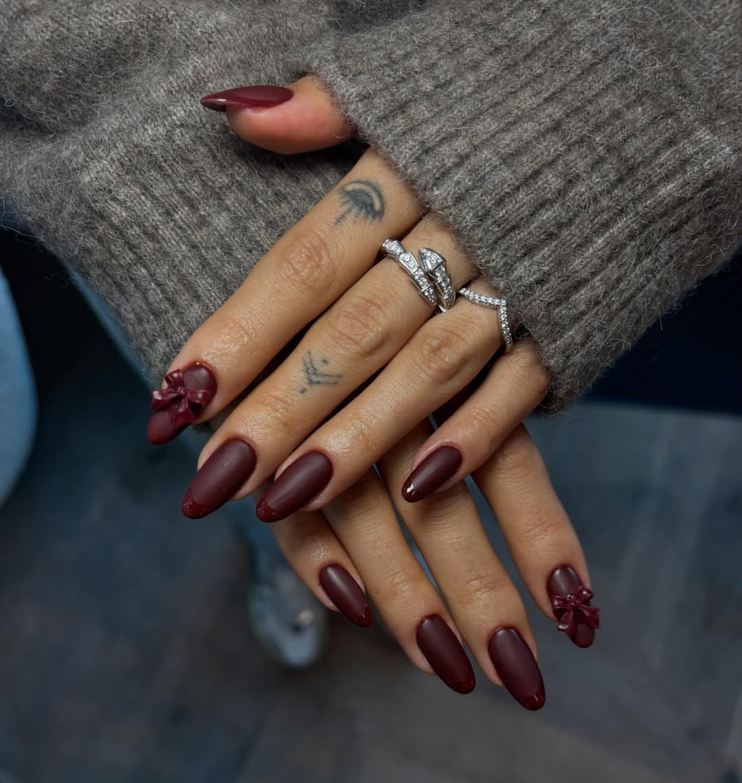 Chic burgundy nails with elegant bow accents