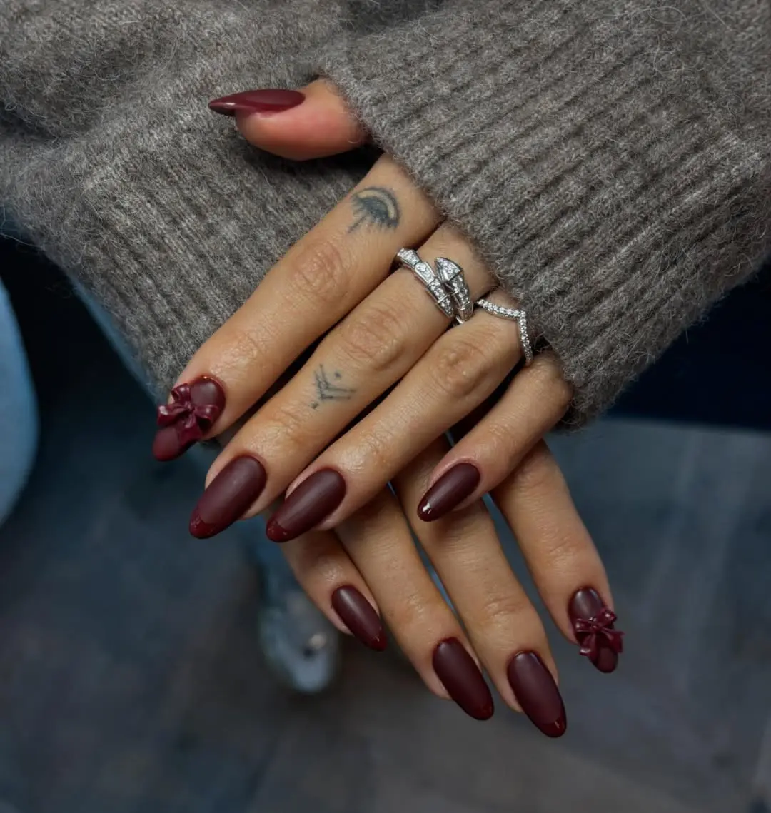 Chic burgundy nails with elegant bow accents