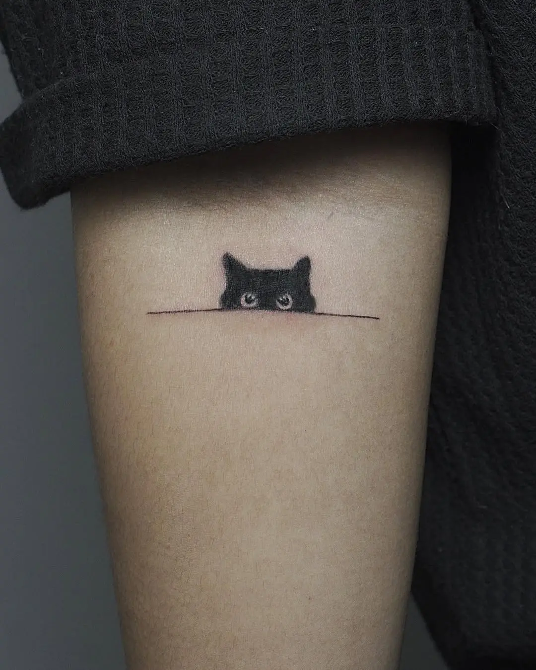 Charming cat peeking minimalist tattoo design