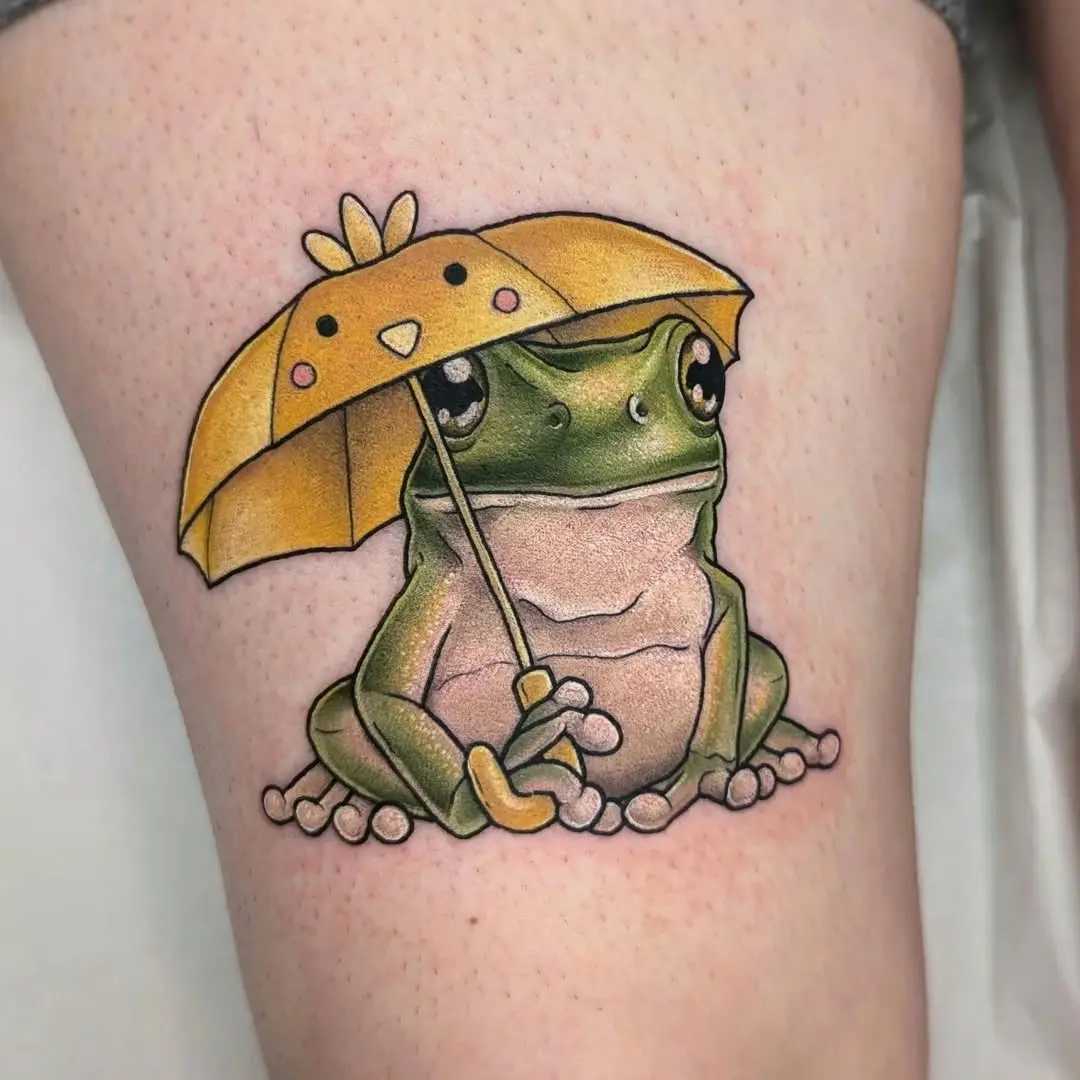 Charming frog tattoo with colorful umbrella design.