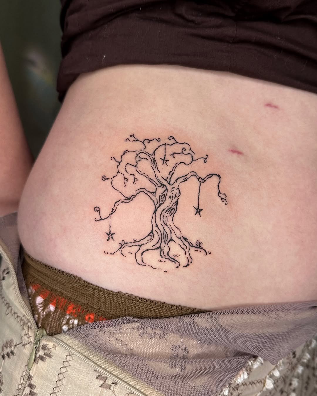 Intricate tree tattoo with whimsical stars