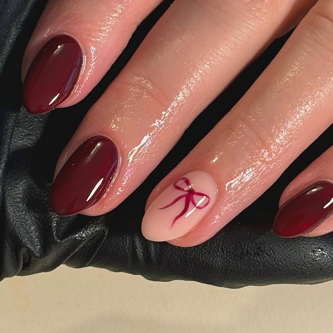 Stylish burgundy nails with a playful touch.