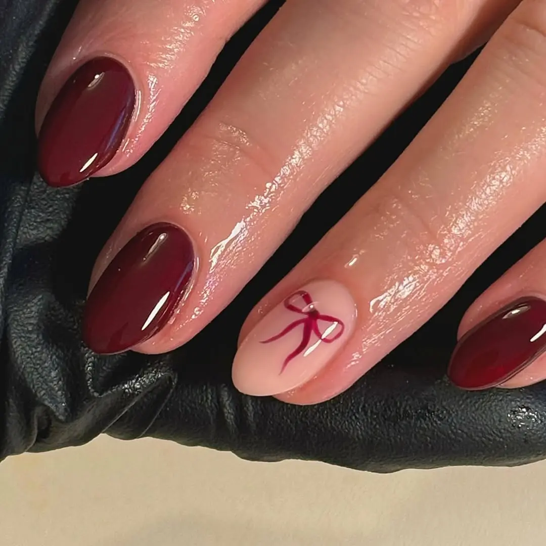 Stylish burgundy nails with a playful touch.