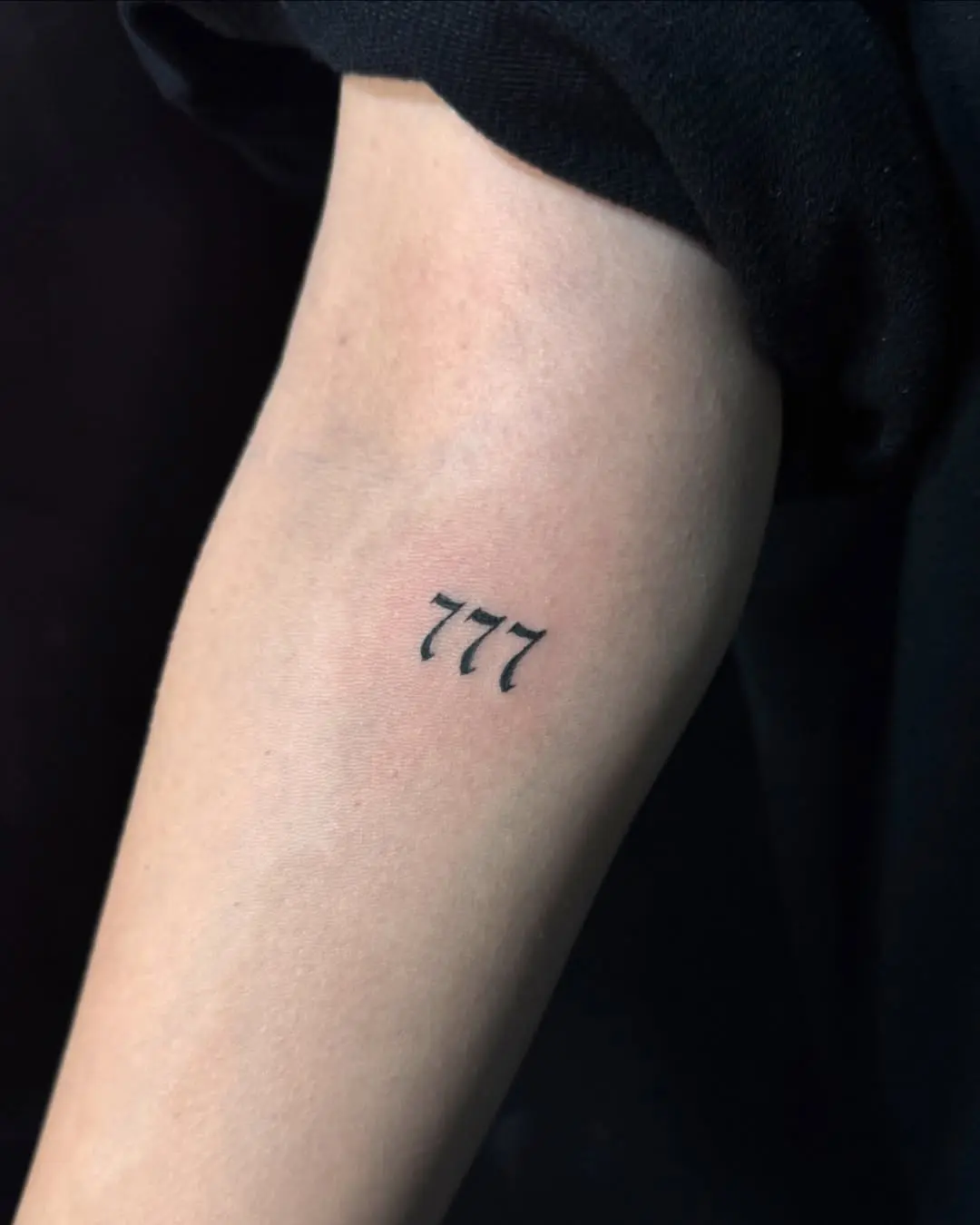 Minimalist 777 tattoo with fine lines