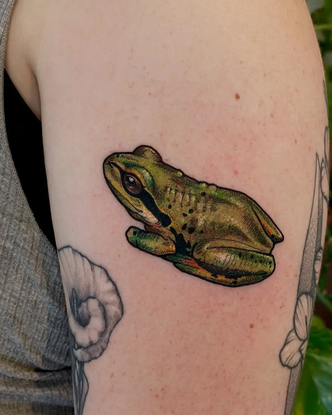 Vivid green frog tattoo on arm