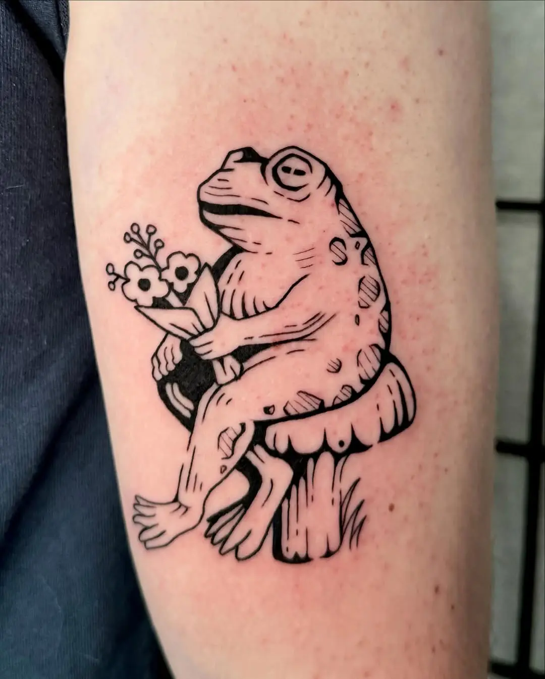 Charming frog tattoo with floral elements