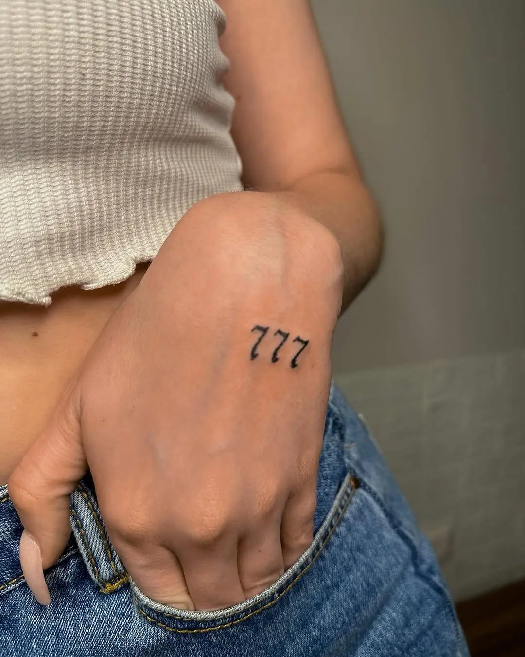 Stylish minimalist 777 tattoo on the hand