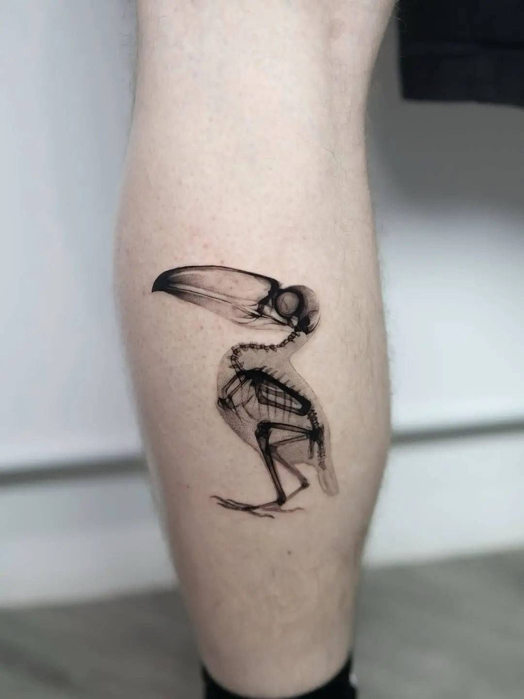 Striking minimalist bird skeleton tattoo design