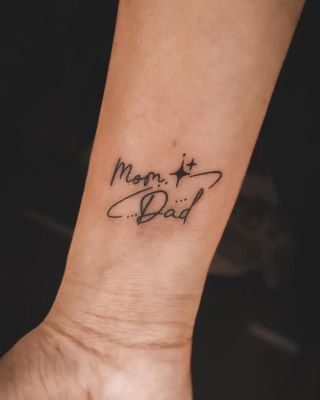 Elegant mom and dad tattoo in cursive