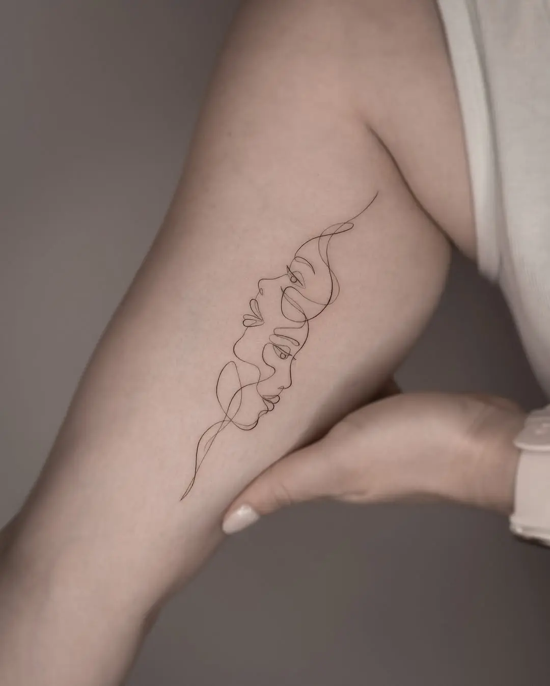 Elegant one-line female faces tattoo design
