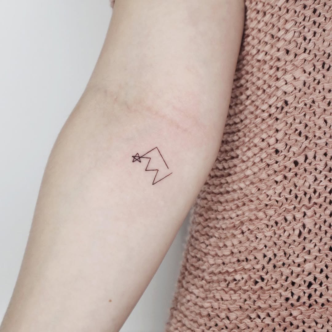 Minimalist mountain and star tattoo design