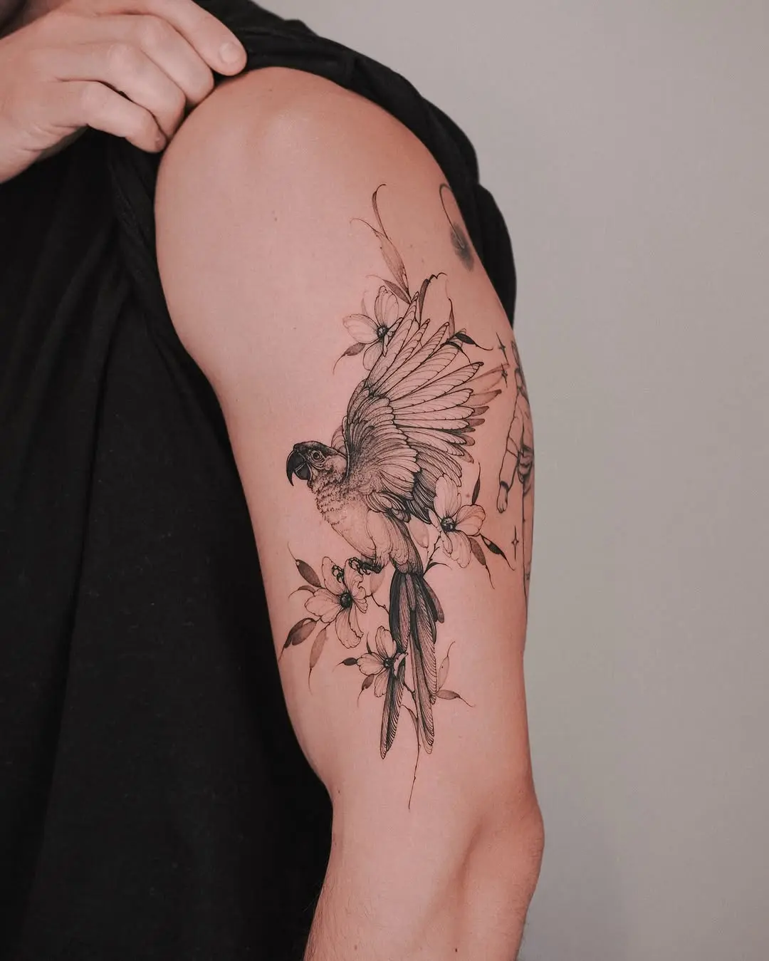 Intricate parrot tattoo with floral accents