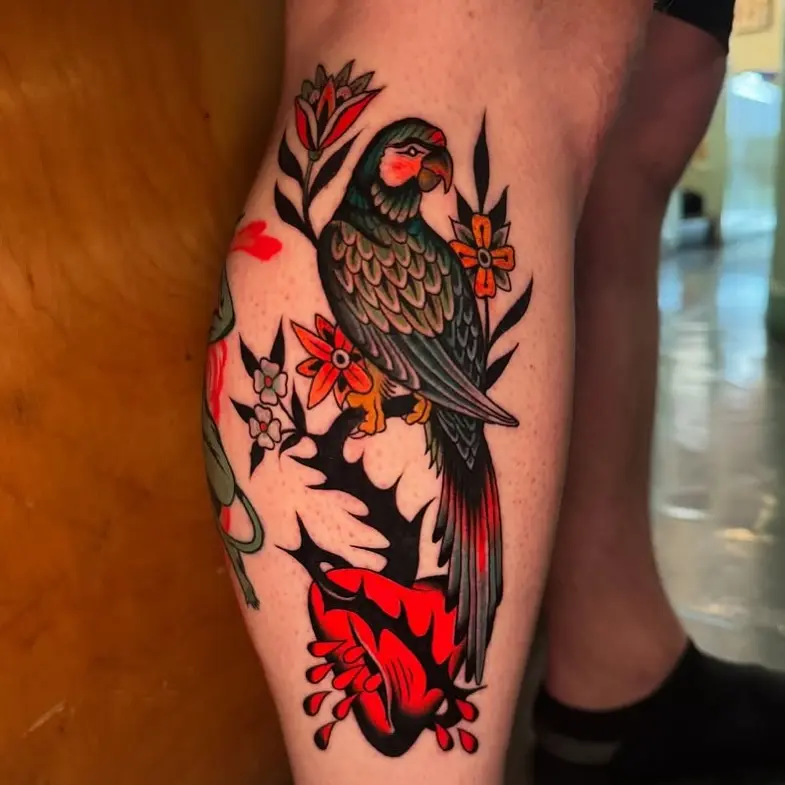 Bold parrot tattoo with vibrant floral accents