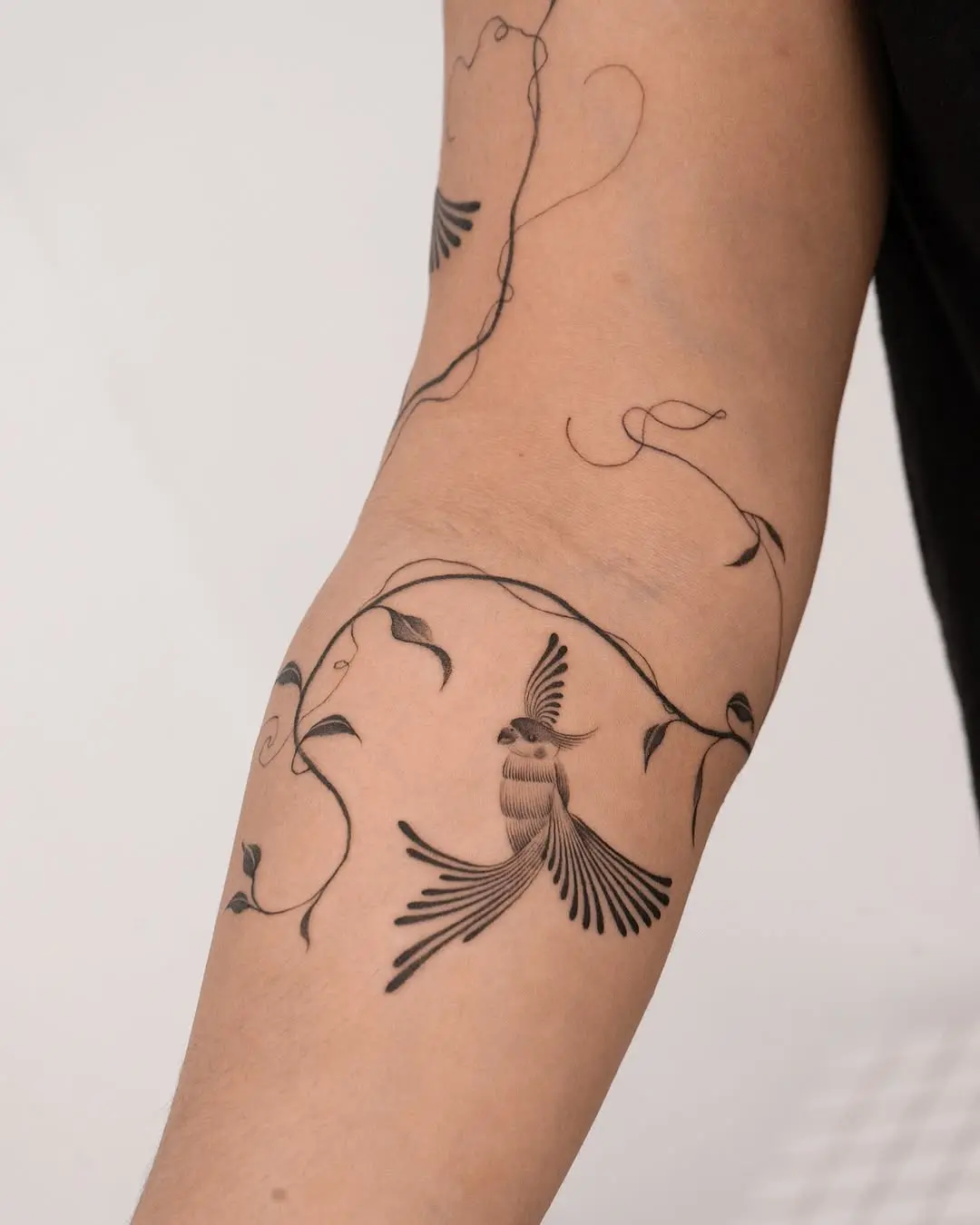 Stylish parrot tattoo with vine accents
