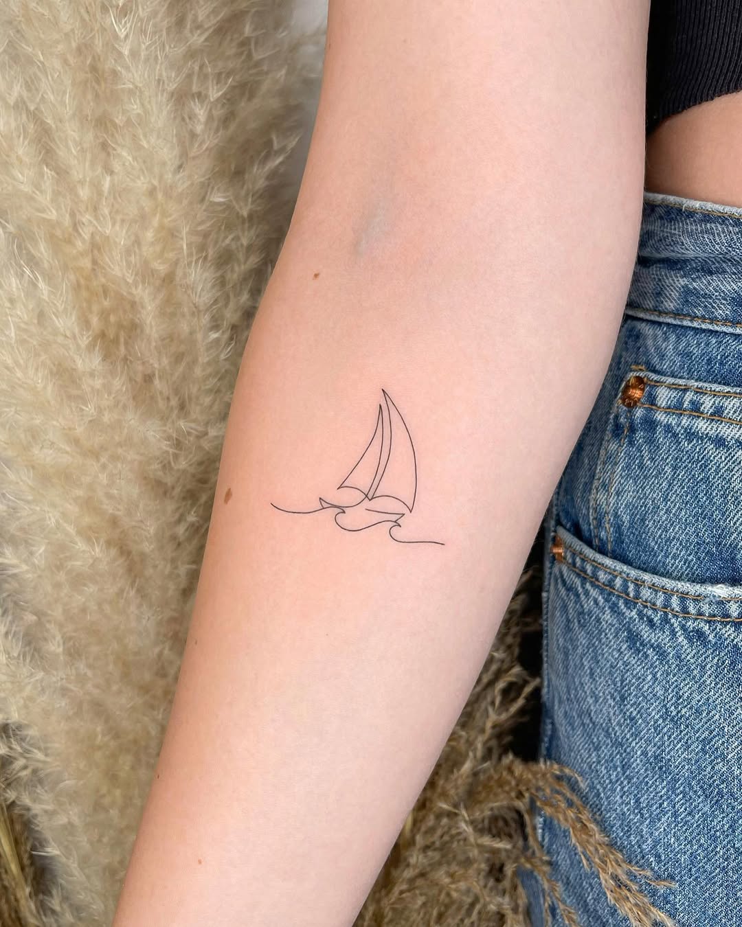 Elegant one-line sailboat tattoo design