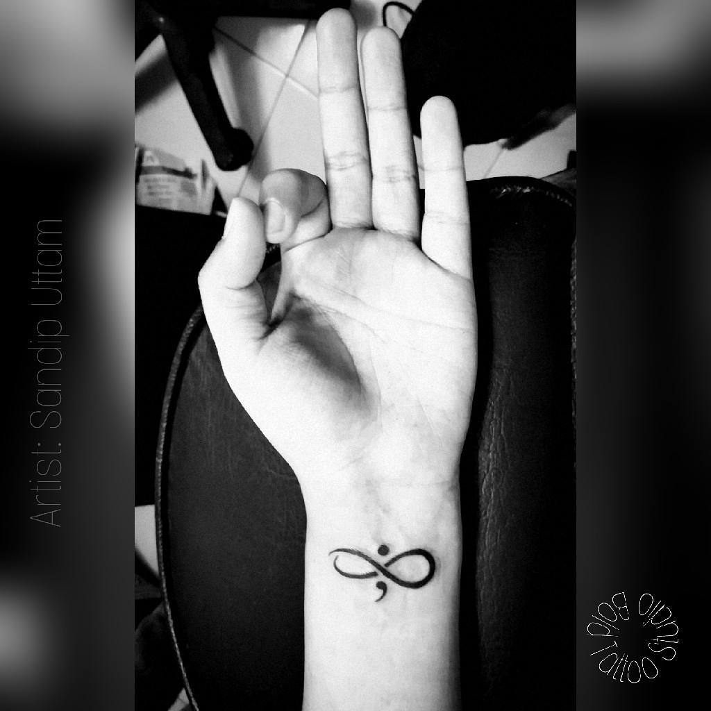 Minimalistic semicolon tattoo with artistic flair