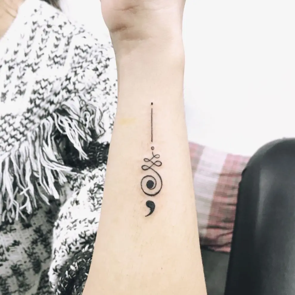 Elegant minimalist semicolon tattoo on forearm