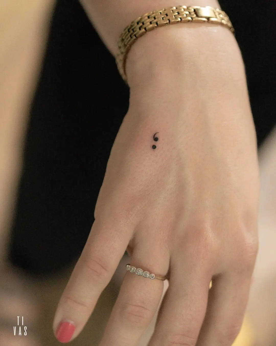 Minimalist semicolon tattoo on a wrist