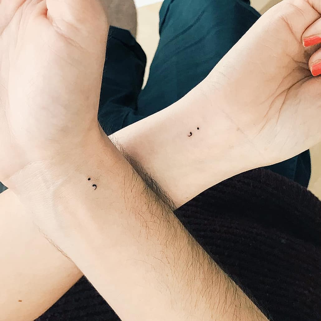 Elegant minimalist semicolon tattoos on wrists
