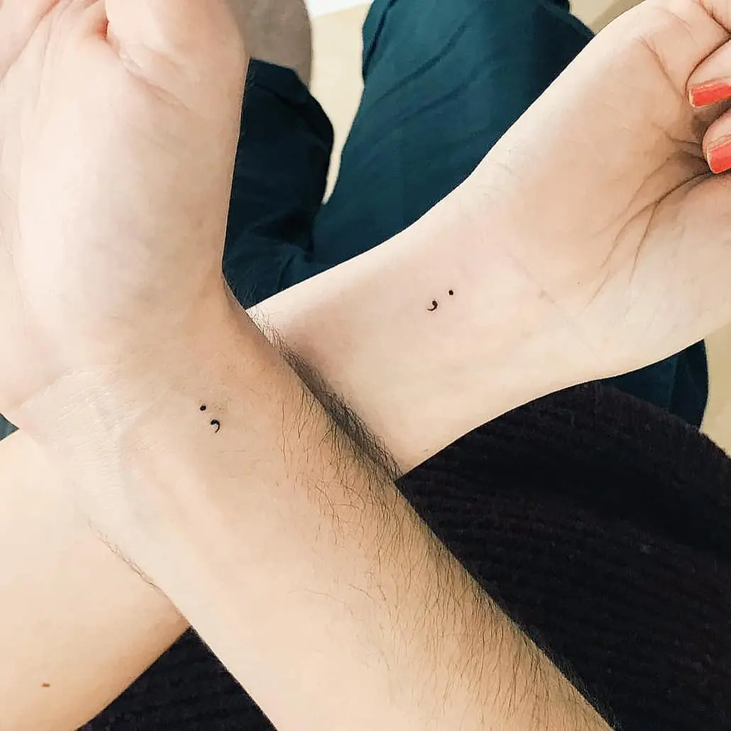 Elegant minimalist semicolon tattoos on wrists