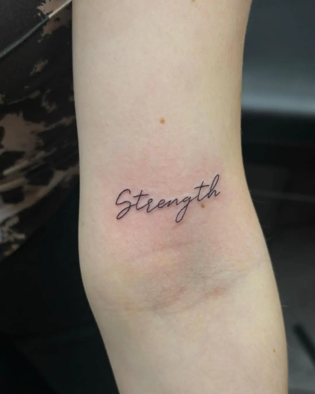 Elegant Strength Tattoo in Script Font