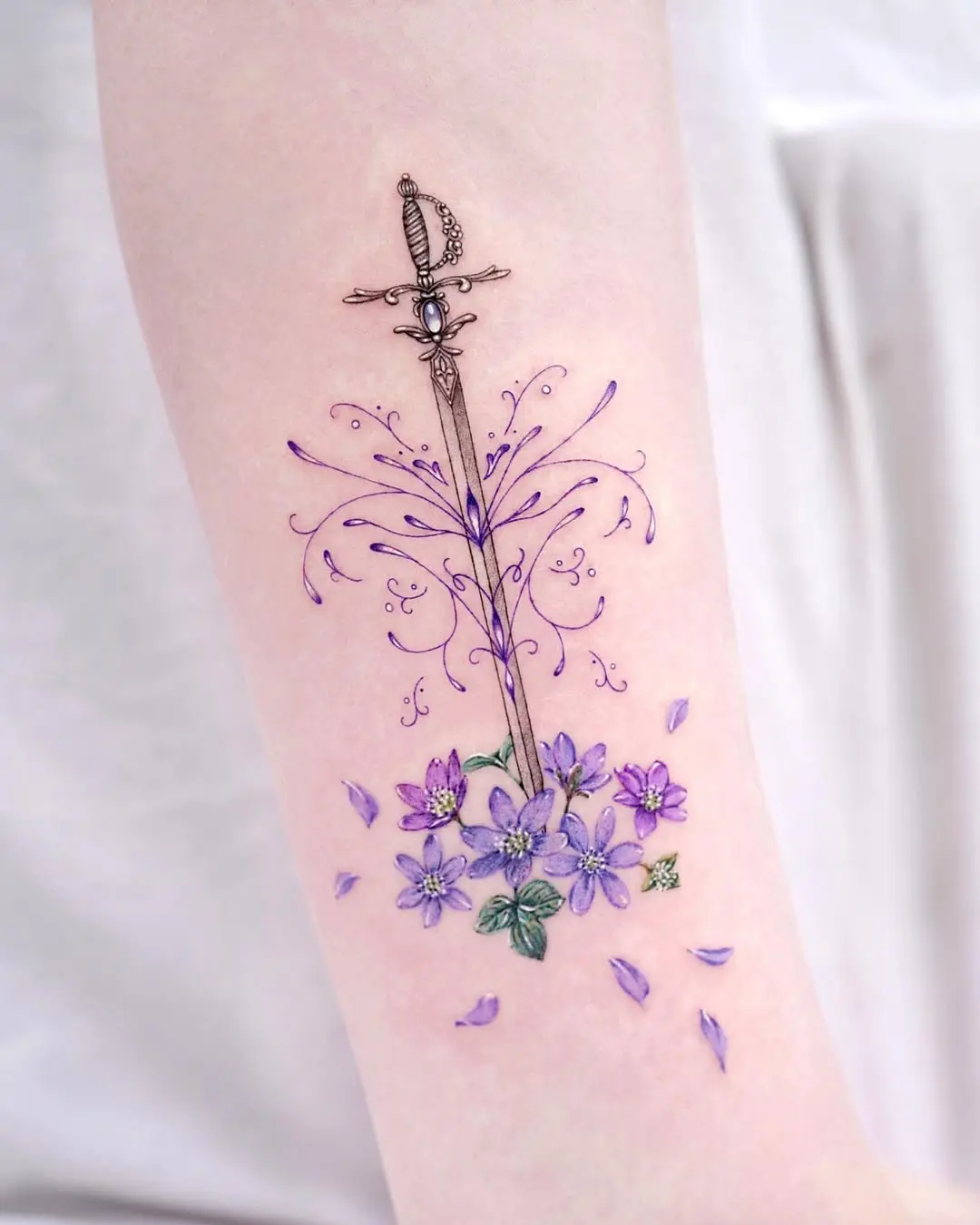 Floral sword tattoo representing inner strength