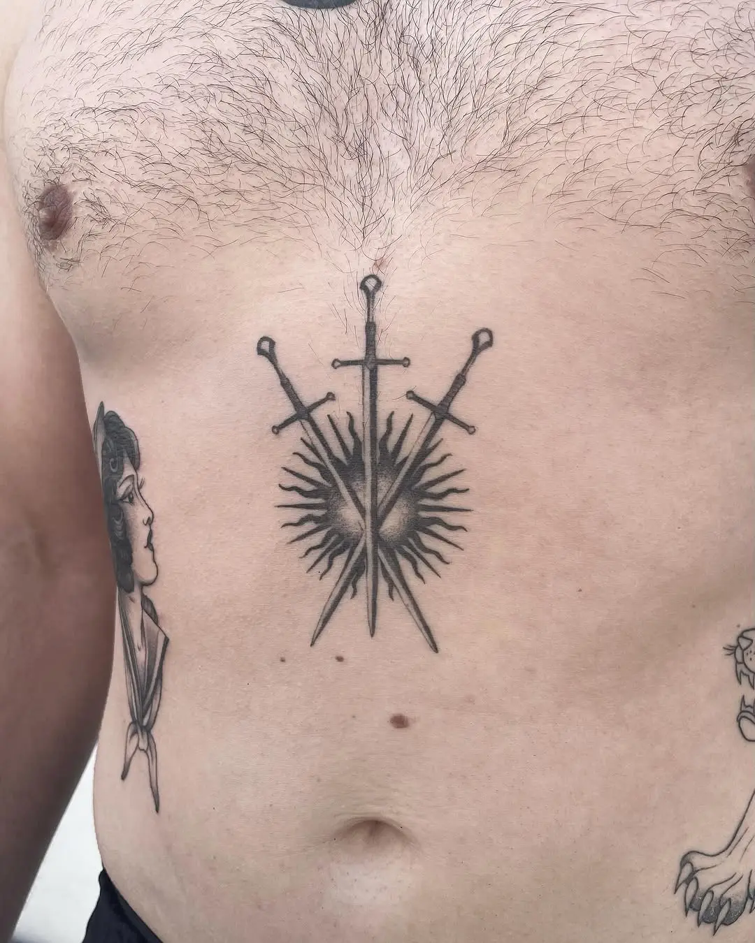 Bold chest tattoo featuring three striking swords