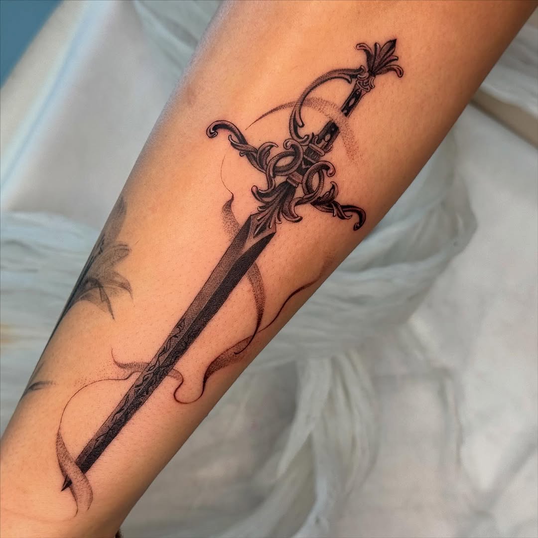 Elegant sword tattoo with intricate details.
