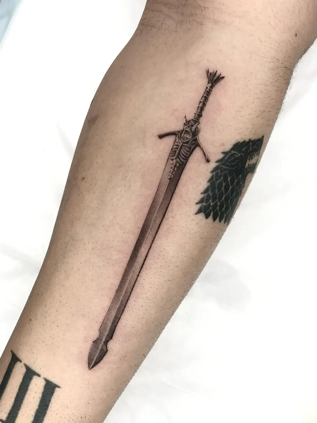 Realistic sword tattoo showcasing intricate detailing