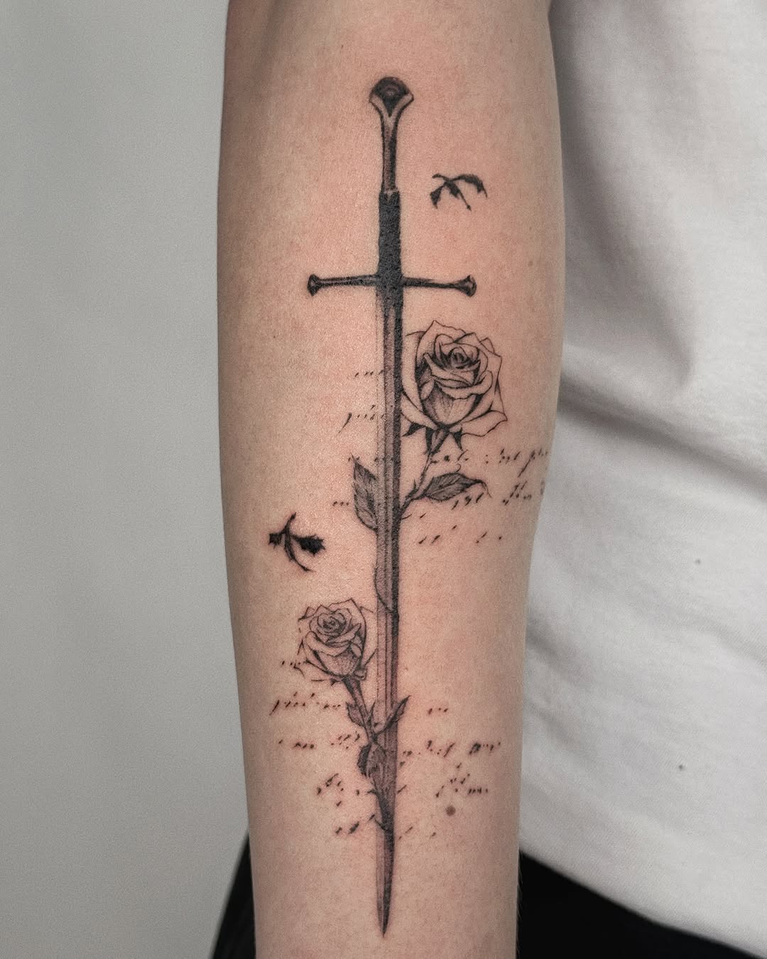 Intricate sword with blooming roses tattoo design