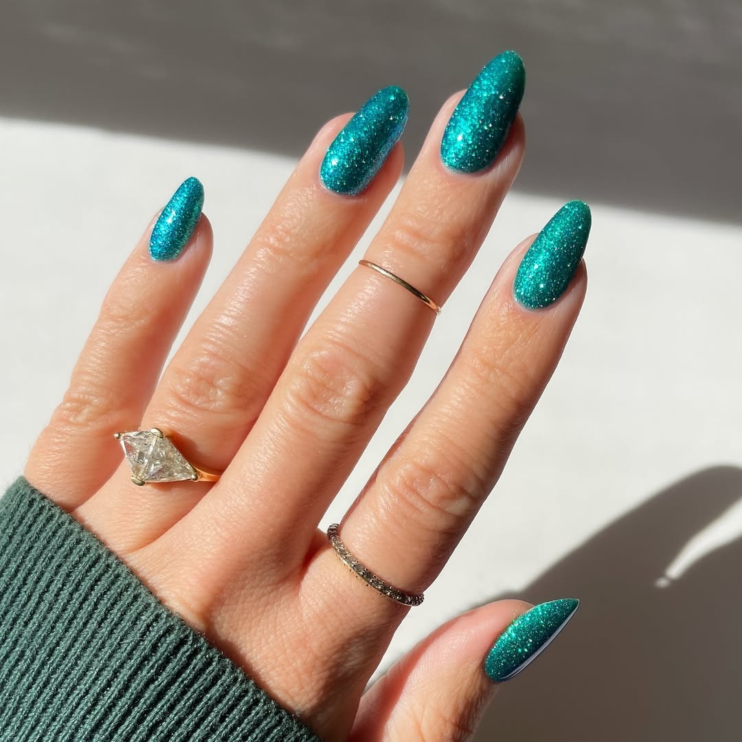 Vibrant teal glitter nails shine brilliantly