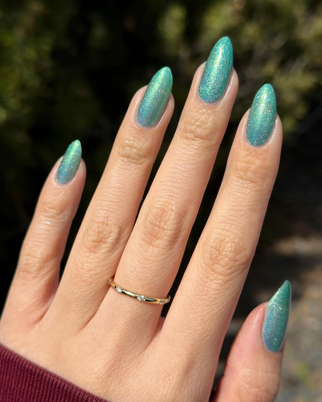 Vibrant teal nails with a shimmering finish